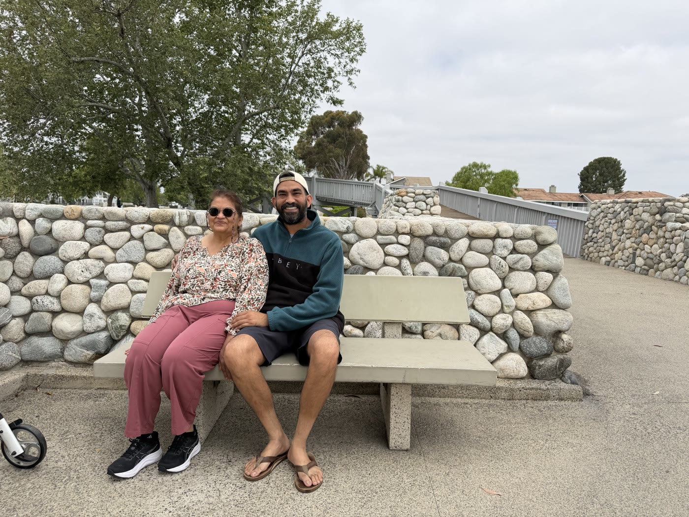 My mom and me sitting together on a stone bench